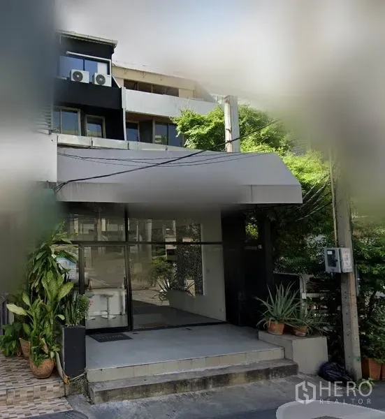 อาคารพาณิชย์ ให้เช่าในWatthana, Bangkok - ทางเข้าอาคารพาณิชย์หน้ากระจกพร้อมกันสาด รายล้อมด้วยกระถางต้นไม้