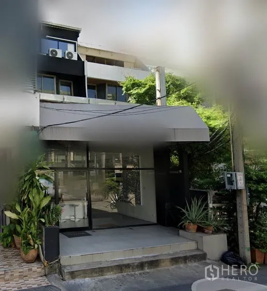 อาคารพาณิชย์ ให้เช่าในWatthana, Bangkok - ทางเข้าอาคารพาณิชย์หน้ากระจกพร้อมกันสาด รายล้อมด้วยกระถางต้นไม้