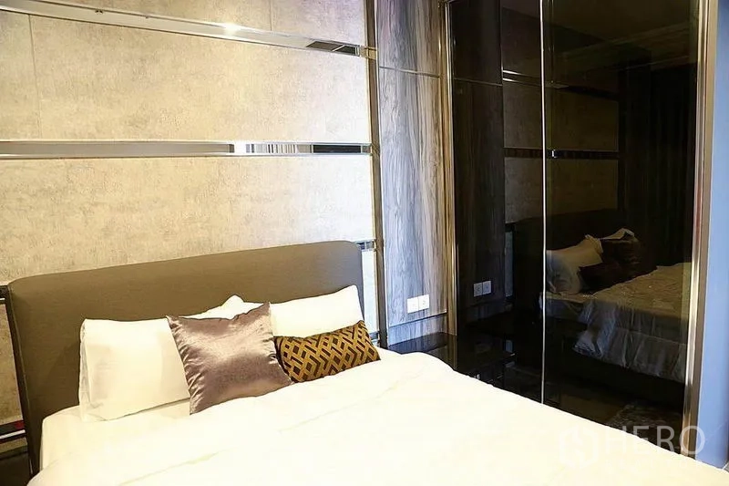 คอนโด ให้เช่าในHuai Khwang, Bangkok - ห้องนอนที่สองพร้อมหัวเตียงบุนวมและตู้เสื้อผ้าบานกระจกโทนไม้เข้ม