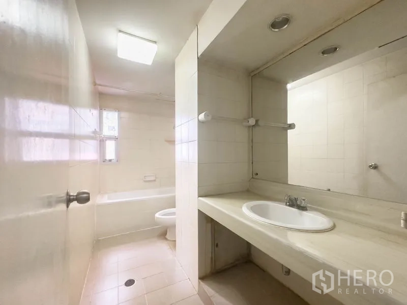 คอนโด ขายในBang Na, Bangkok - ห้องน้ำอีกห้องพร้อมเคาน์เตอร์ยาว อ่างล้างหน้า และอ่างอาบน้ำ.