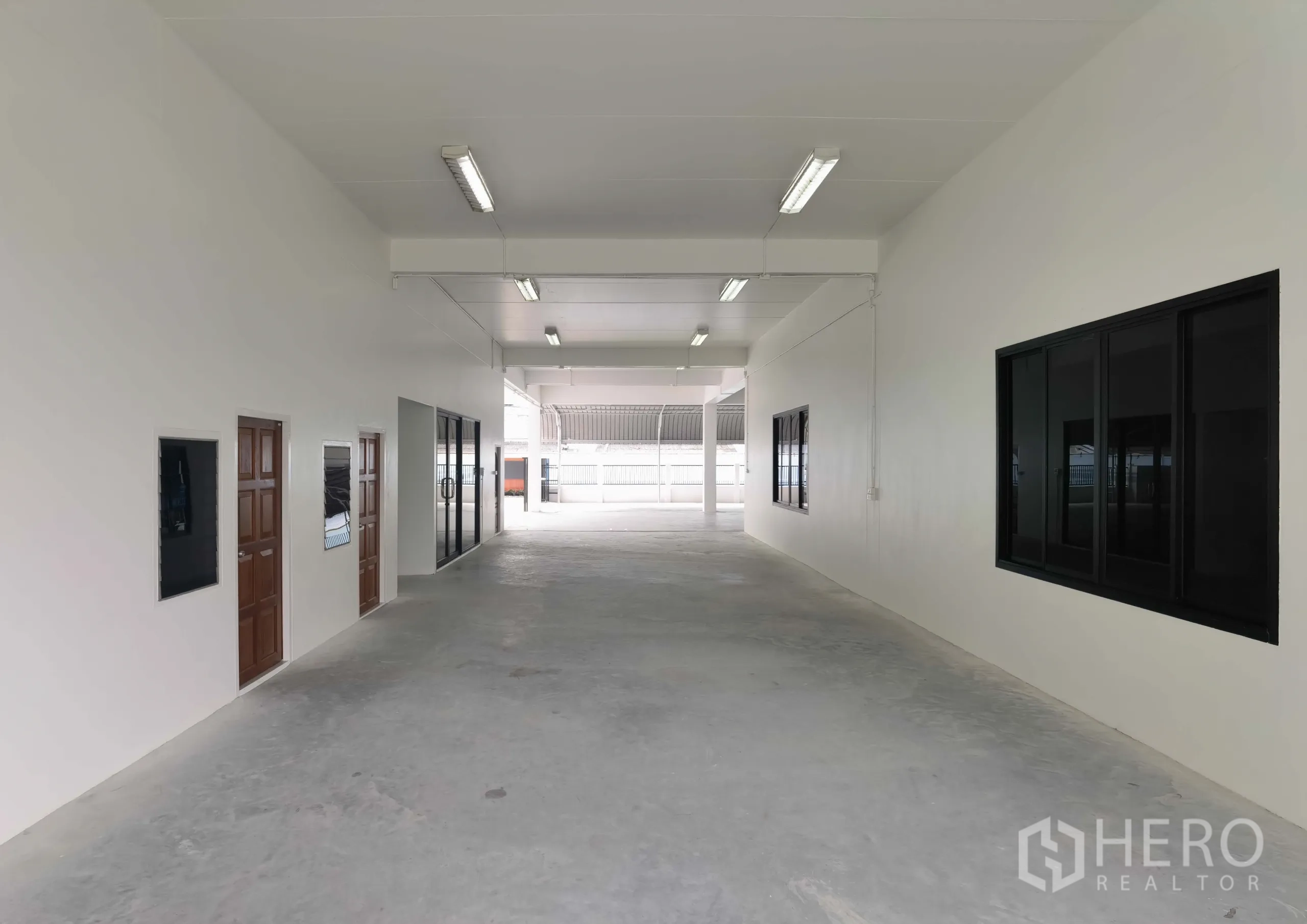 คลังสินค้า ให้เช่าในSamut Prakan - โถงภายในสะอาด มีห้องสำนักงานและประตูกระจก ไฟฟลูออเรสเซนต์ พื้นคอนกรีตเรียบ