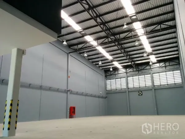 工厂 出租在Samut Prakan - 仓库内部空间开阔，8米高钢结构屋顶，工业照明充足。