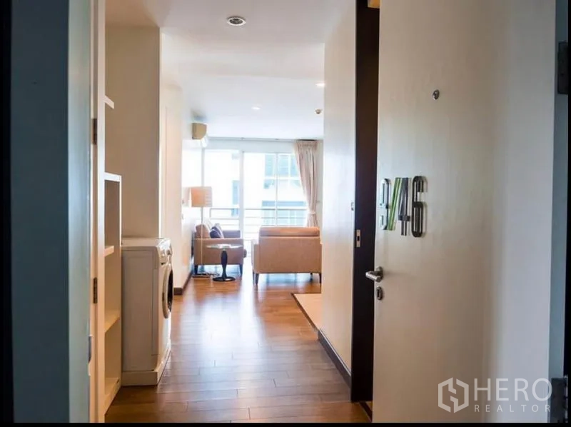 公寓 出租或出售在Phra Khanong, Bangkok - 公寓入门视角，通向采光充足的客厅与阳台门。