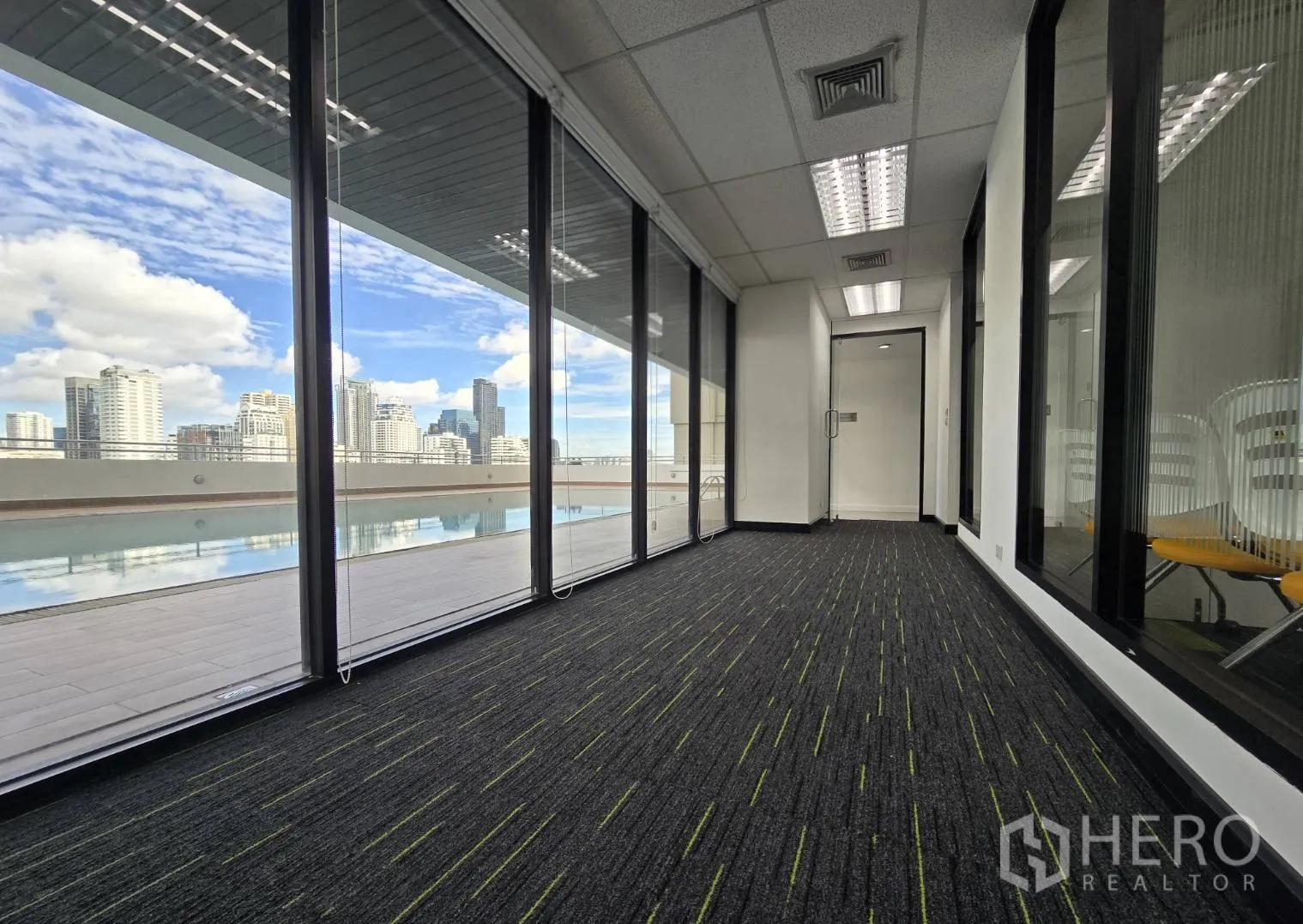 Office Space for rent in Watthana, Bangkok - Hallway with full-height glazing overlooking the pool and skyline.