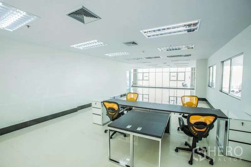 สำนักงาน ให้เช่าในBang Phli, Samut Prakan - โซนออฟฟิศพร้อมโต๊ะยาว เก้าอี้ทำงานสีเหลือง และผนังกระจกมองออกภายใน