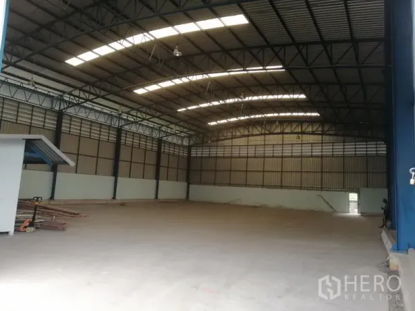 货栈 出租在Lat Krabang, Bangkok - 仓库内部空间开阔，钢结构高屋顶带天窗，地面为光滑混凝土。