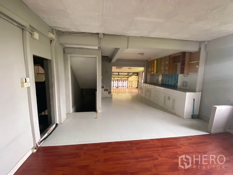 Retail Space for rent in Khlong San, Bangkok - Open floor with long built-in pantry cabinets, white tiles and stair access.