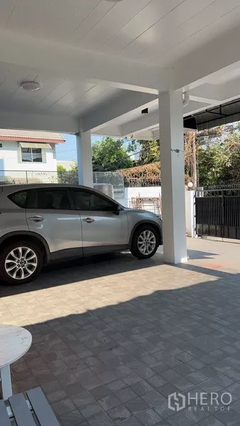 带办公室的家 出租或出售在Phra Khanong, Bangkok - 有顶车棚，停放SUV，地面铺砖。