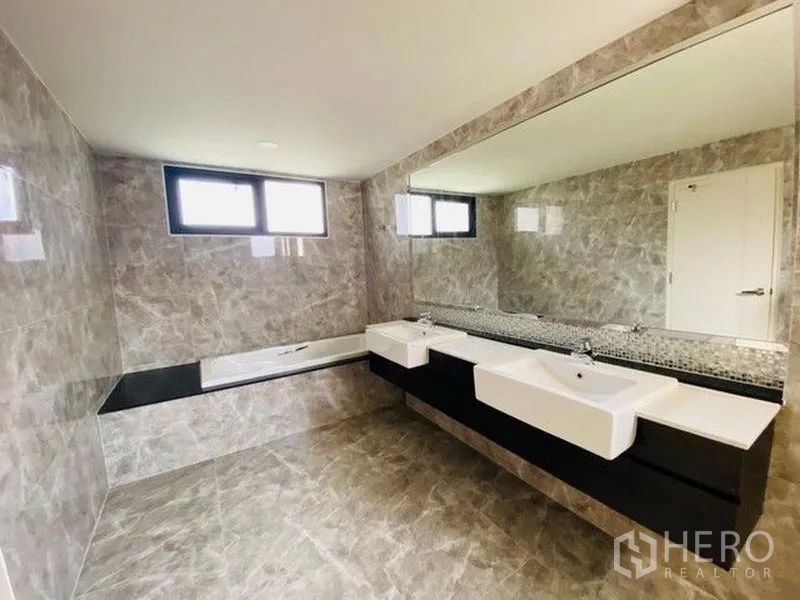 Detached House for sale in Bang Phli, Samut Prakan - Luxury bathroom with bathtub, double sinks and full-length mirror on gray tiles.