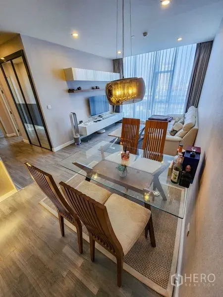 คอนโด ให้เช่าหรือขายในBang Rak, Bangkok - พื้นที่รับประทานอาหารและนั่งเล่นแบบเปิดโล่ง โต๊ะกระจก โคมแขวน และหน้าต่างกระจกเต็มบาน