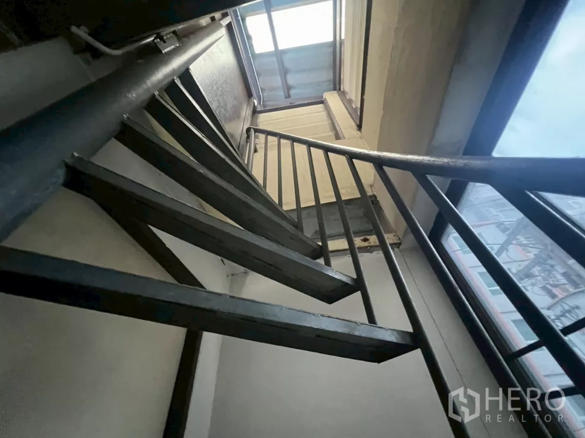 店屋 出租在Watthana, Bangkok - 仰视黑色金属旋转楼梯，通往屋顶舱口。