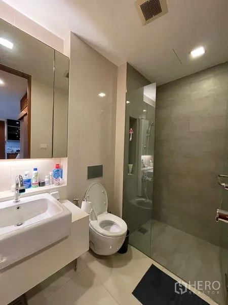 公寓 出售在Khlong Toei, Bangkok - 现代化浴室，设壁挂式洗手台、坐便器与玻璃淋浴间，配中性瓷砖。