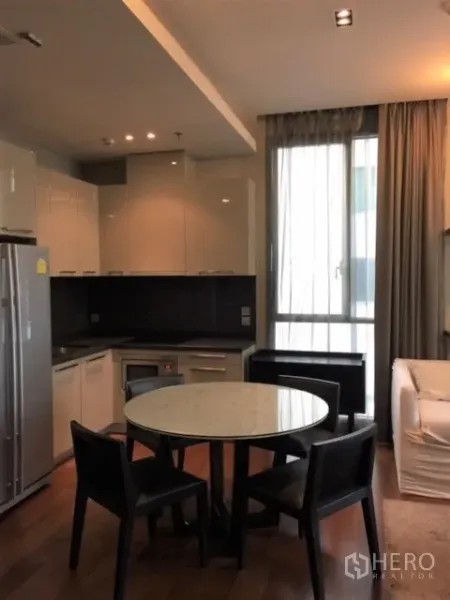 คอนโด ให้เช่าหรือขายในWatthana, Bangkok - ครัวแบบเปิด ตู้สีขาว ตู้เย็นขนาดใหญ่ และโต๊ะอาหารหินอ่อนทรงกลม