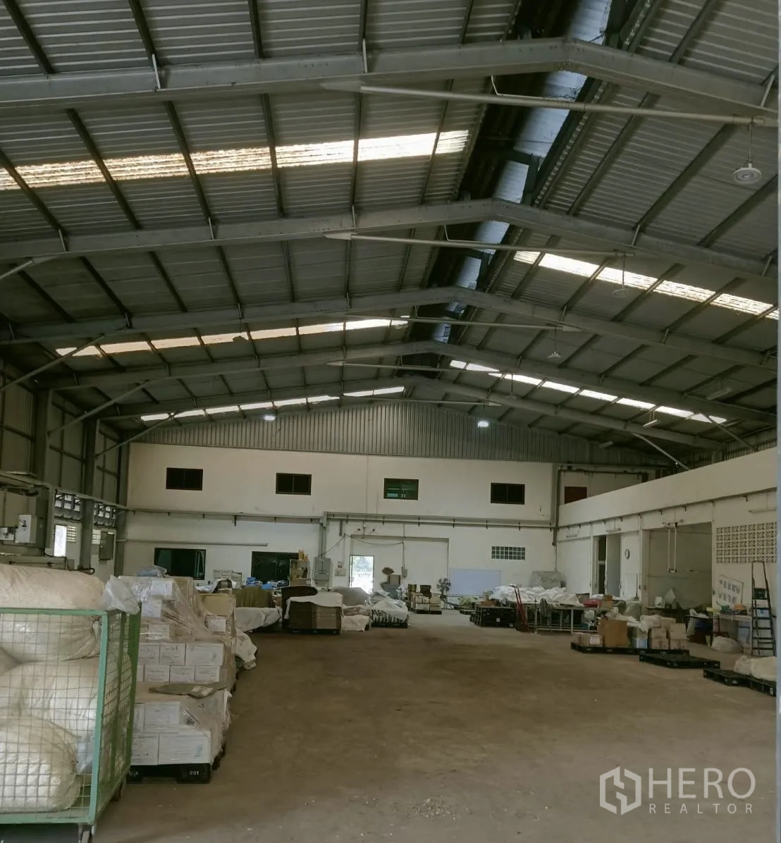 โรงงาน for rent or sale in Nong Suea, Pathum Thani - พื้นที่คลังสินค้าโล่ง หลังคาโครงเหล็กสูงมีแผ่นโปร่งแสง พื้นคอนกรีต และบล็อกออฟฟิศด้านหลัง