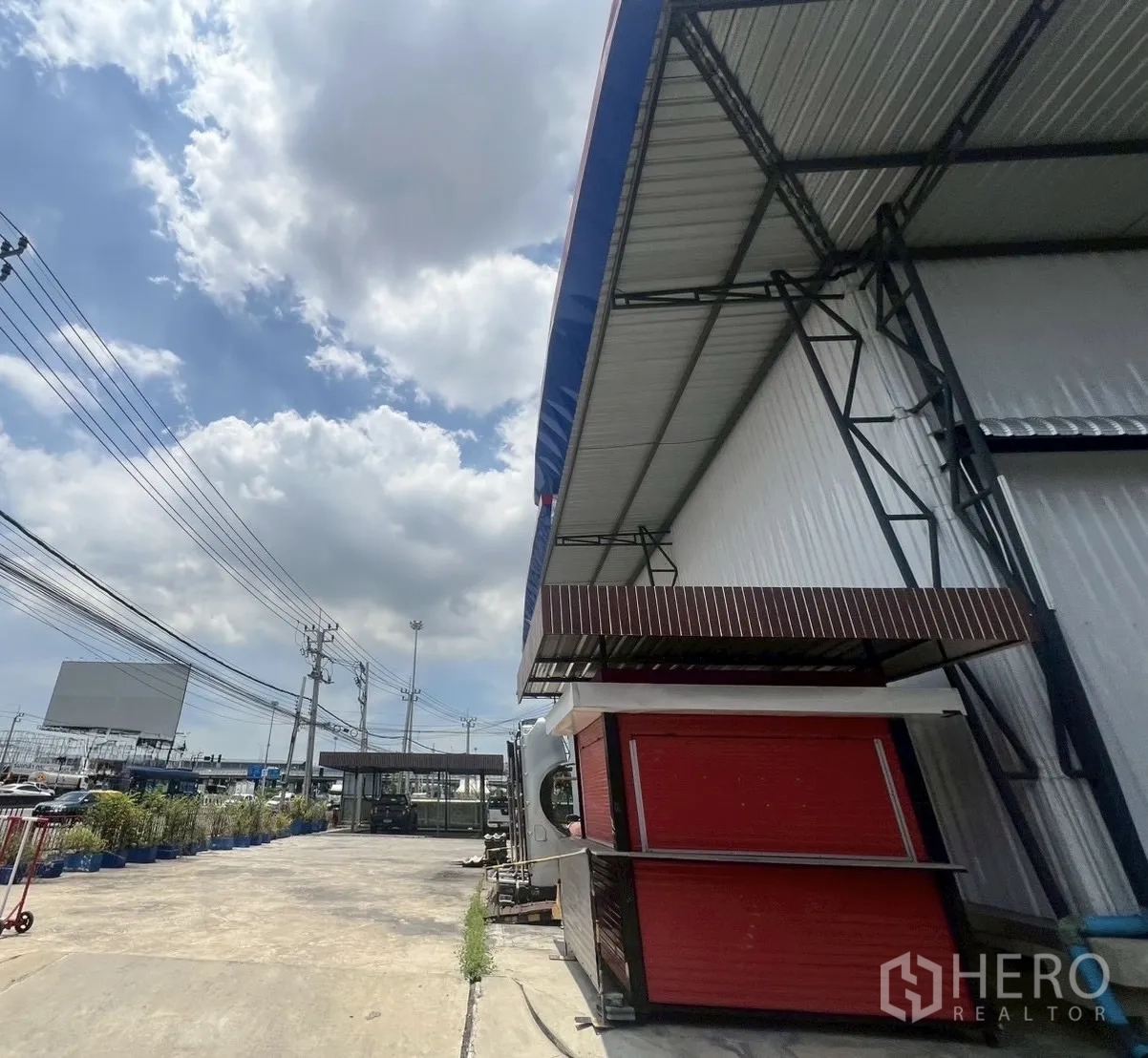 Warehouse for rent in Lat Krabang, Bangkok - Wide concrete driveway, gatehouse and roadside utilities next to the warehouse.