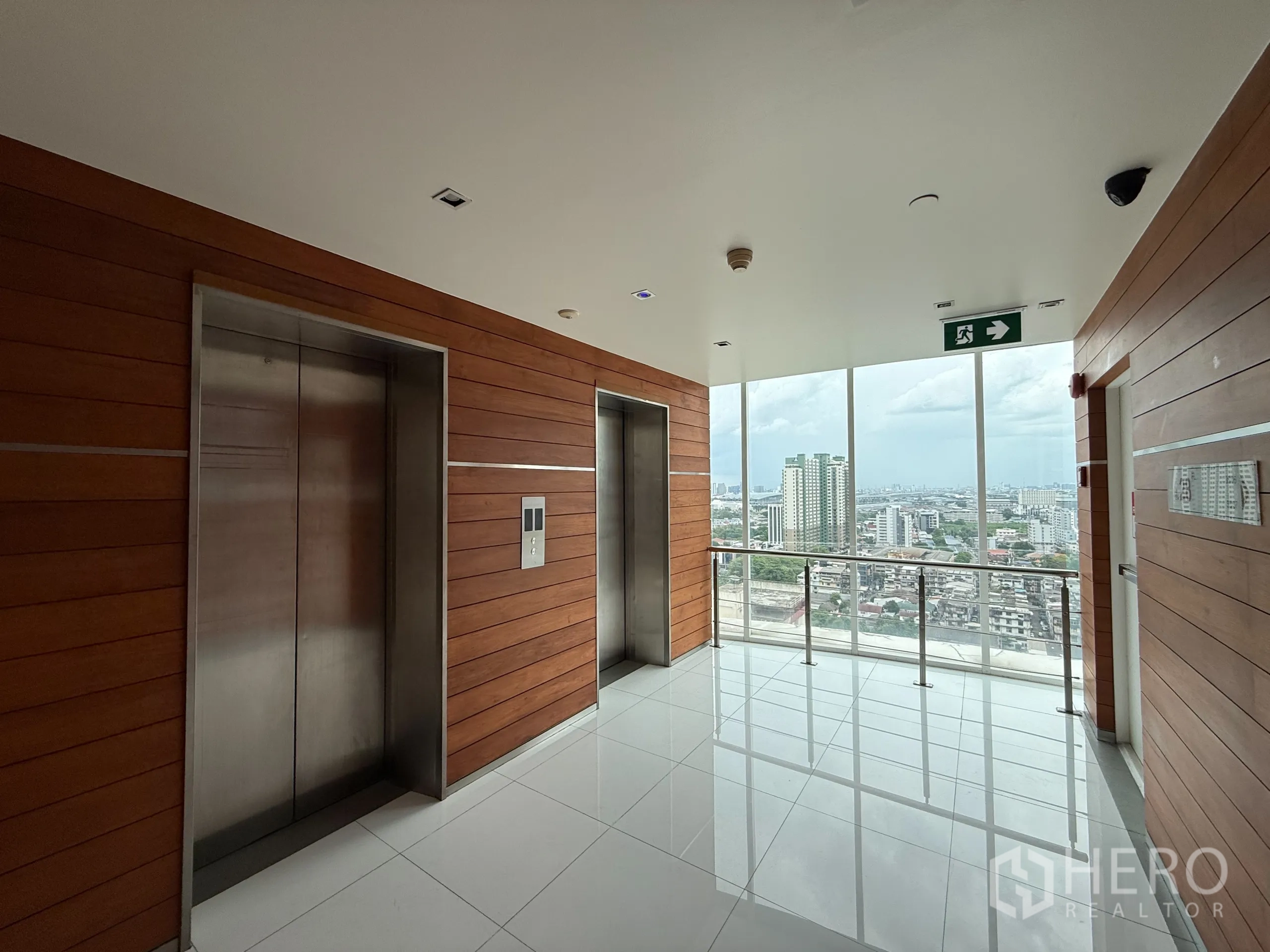 คอนโด ให้เช่าในPhaya Thai, Bangkok - โถงลิฟต์ผนังไม้ พร้อมลิฟต์สแตนเลสสองตัว และหน้าต่างบานใหญ่เห็นวิวเมือง