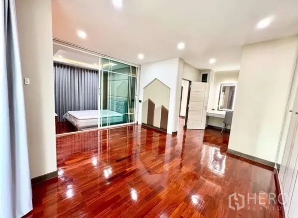 Detached House for rent in Phasi Charoen, Bangkok - Spacious upper room with glossy hardwood floors and a glass partition to the bedroom.