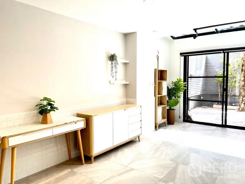 Townhouse for rent in Khlong Toei, Bangkok - Bright Ekkamai townhouse living area with skylight, built-in cabinets and sliding doors to a private patio.