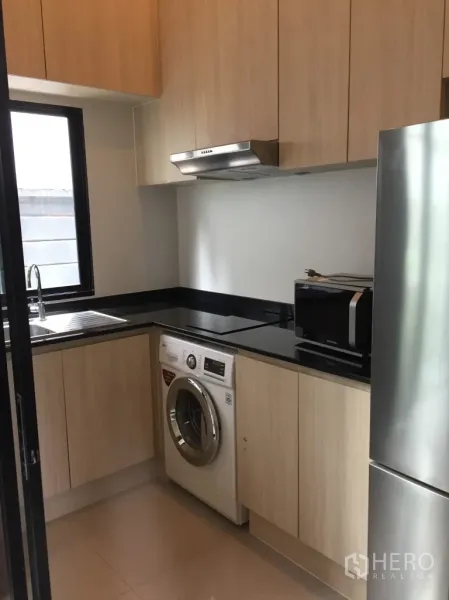 ทาวน์เฮาส์ ให้เช่าในSuan Luang, Bangkok - ครัวปิดบิวท์อิน โทนไม้อ่อน ท็อปหินสีดำ มีหน้าต่าง อ่างล้างจาน เครื่องดูดควัน ตู้เย็น และเครื่องซักผ้า