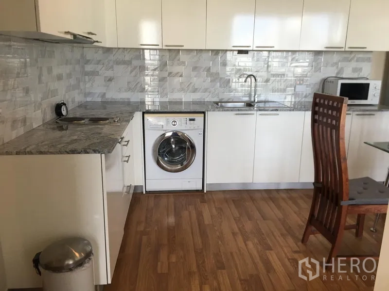 คอนโด ให้เช่าในWatthana, Bangkok - ครัวแผนผังเปิดมีเครื่องซักผ้า เคาน์เตอร์ยาว และตู้เก็บของ