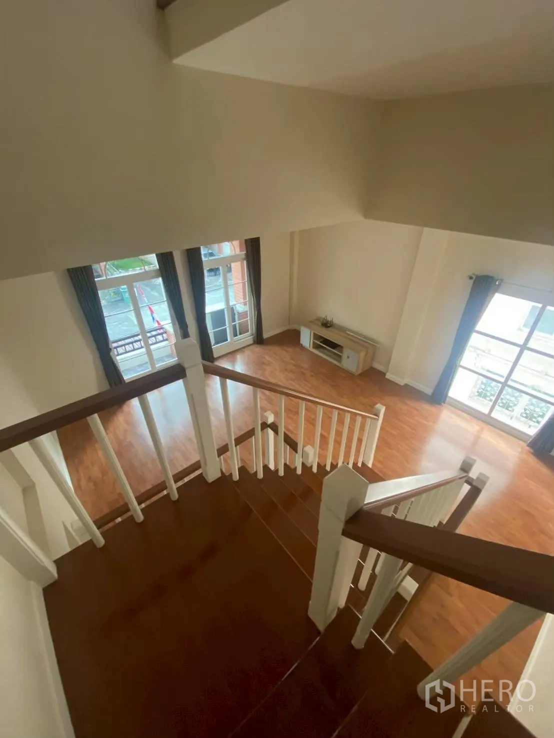 Townhouse for rent in Bang Kapi, Bangkok - Staircase overlooking spacious living room with wood floors.
