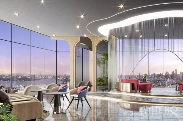 Condominium for sale in Khlong Toei, Bangkok - Panoramic sky lounge with curved features, lounge seating, and floor-to-ceiling glass overlooking a lake and city at sunset.