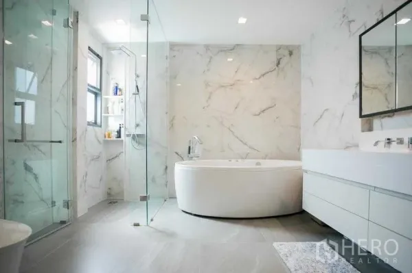 Detached House for rent in Bangkok - Luxury main bathroom featuring a round soaking tub, glass shower enclosure and marble walls.