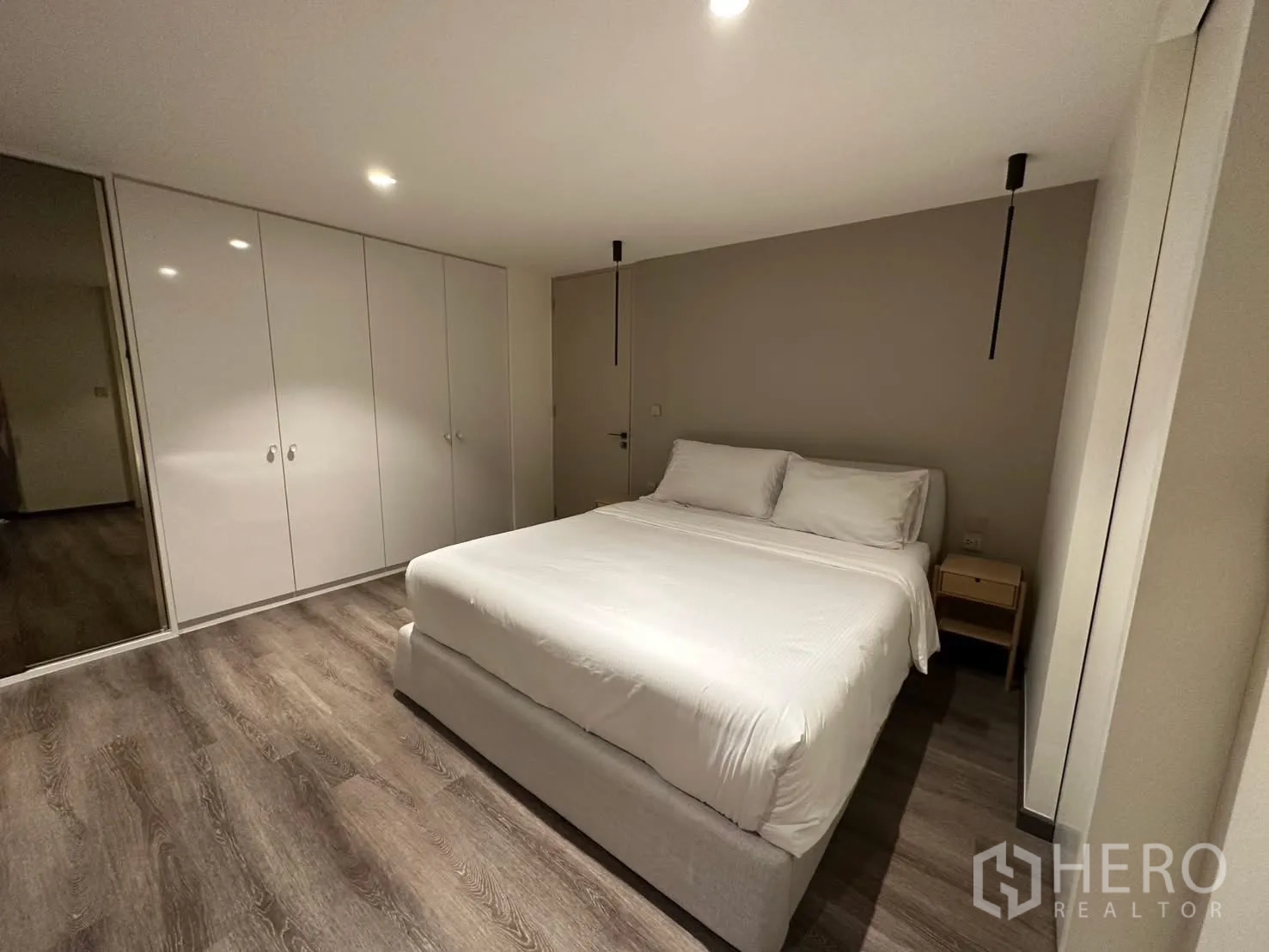 Condominium for rent or sale in Watthana, Bangkok - Bedroom with double bed, built-in wardrobes, and wood floors.