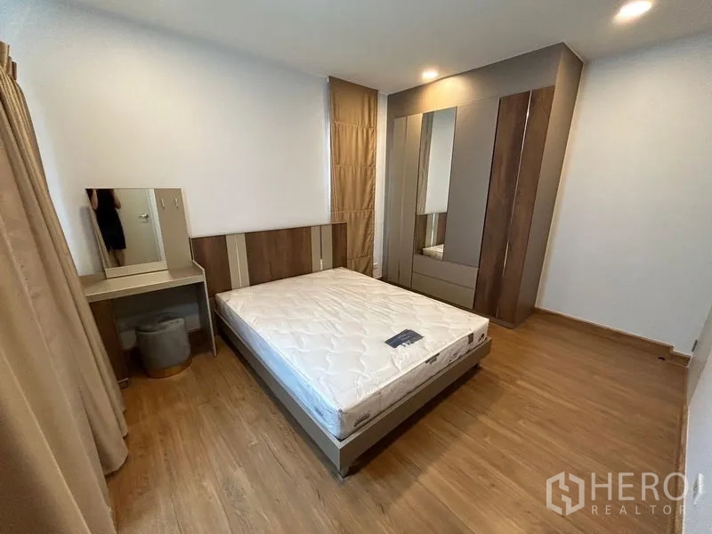 Detached House for rent in Bang Phli, Samut Prakan - Bedroom with double bed, wardrobe and dressing table on wood floor.