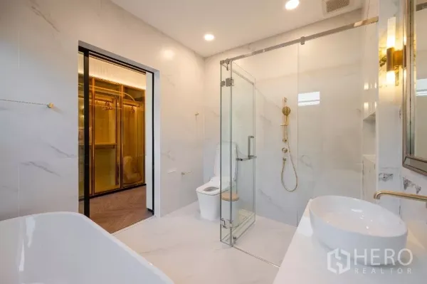 Detached House for rent or sale in Khlong Toei, Bangkok - Luxury bathroom with glass shower, freestanding tub, marble walls and gold fixtures.