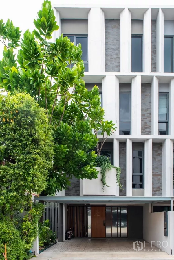 ทาวน์เฮาส์ ให้เช่าในLat Phrao, Bangkok - ด้านหน้าอาคารทาวน์โฮมโมเดิร์น ครีบแนวตั้งและช่องจอดรถมีประตูรั้ว