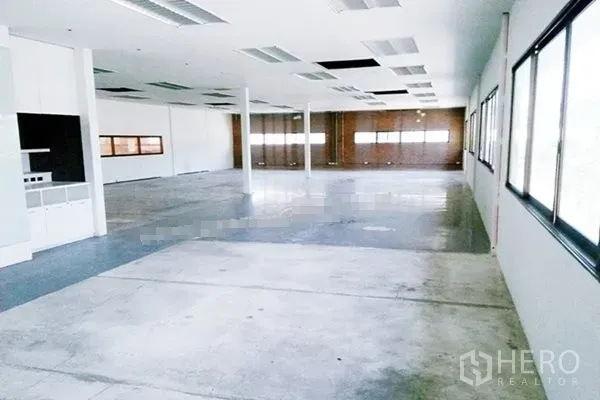 Warehouse for rent in Saphan Sung, Bangkok - Bright open-plan office space inside a warehouse with large windows, white walls and concrete floor.