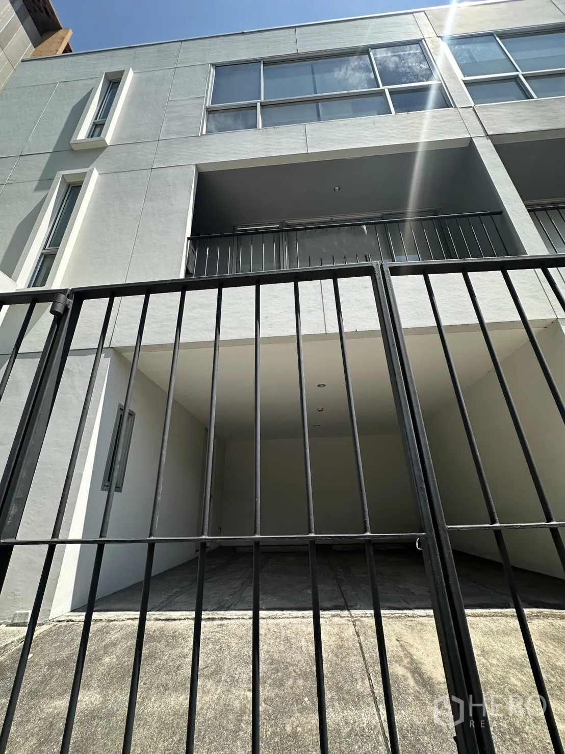 Home Office for rent in Phra Khanong, Bangkok - View through a black metal gate to balconies and large front windows.