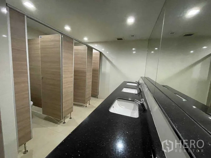 Office Space for rent in Ratchathewi, Bangkok - Row of restroom stalls with long mirrored counter and integrated sinks.