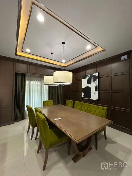 独立式住宅 出租在Bang Kapi, Bangkok - 正式餐厅，长木桌、绿色餐椅与吊灯。