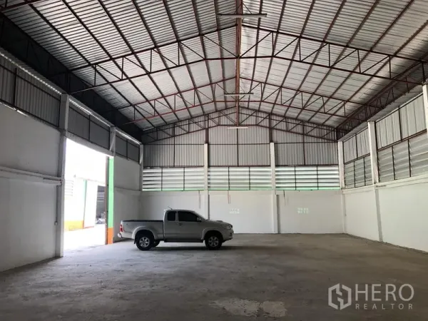 คลังสินค้า ให้เช่าในPathum Thani - พื้นที่โกดังโล่งพื้นคอนกรีต มีรถกระบะจอด แสดงพื้นที่ขนถ่ายกว้างขวาง
