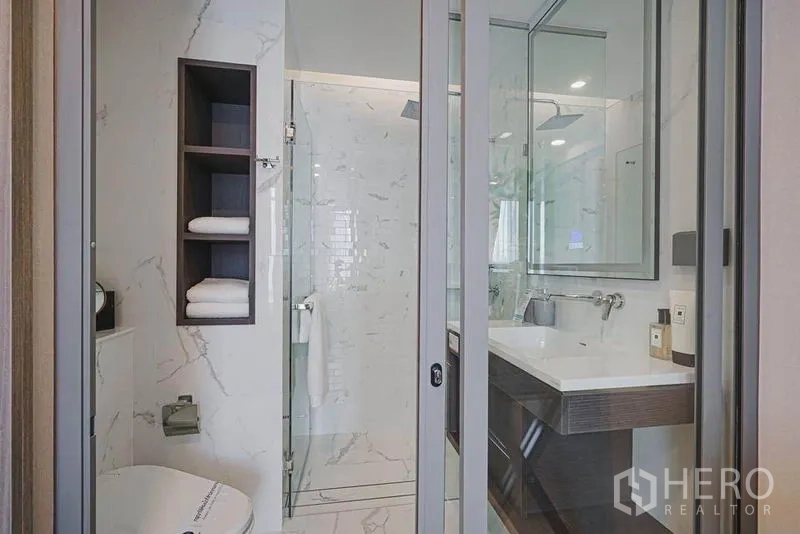 คอนโด ขายในKhlong Toei, Bangkok - ห้องน้ำสไตล์โมเดิร์น พร้อมตู้กระจก อ่างล้างหน้า ฝักบัวกระจก และผนังลายหินอ่อน