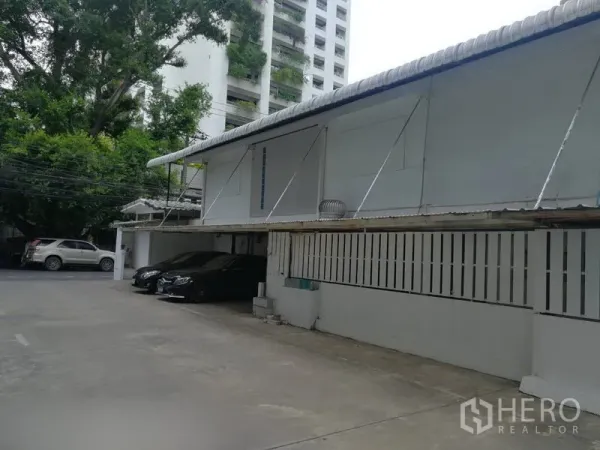 零售空间 出租在Khlong Toei, Bangkok - 带顶棚车位的院内停车区，临近单层商业建筑。
