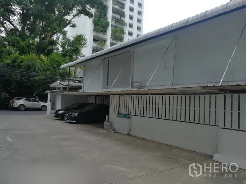 零售空间 出租在Khlong Toei, Bangkok - 带顶棚车位的院内停车区，临近单层商业建筑。