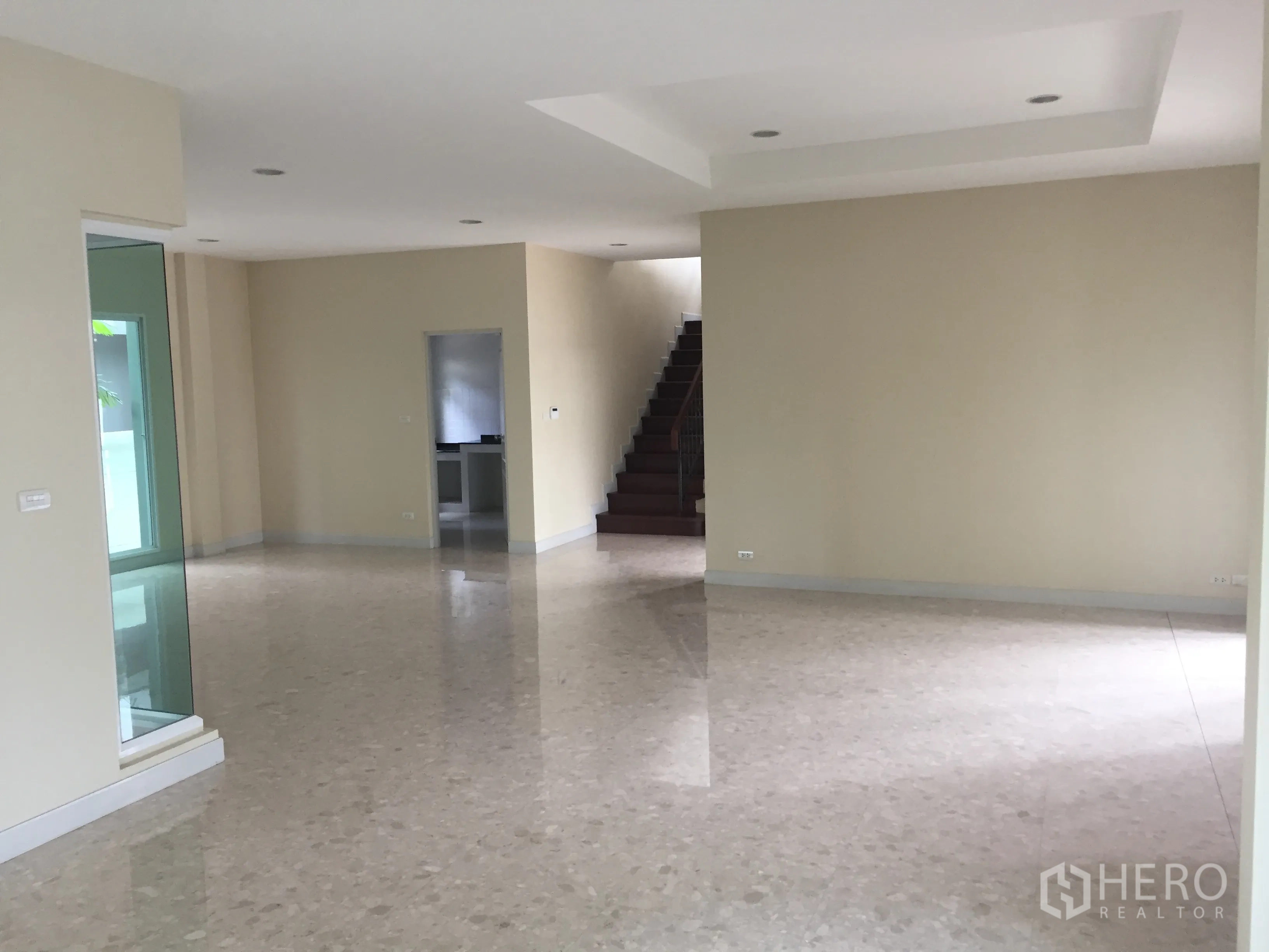 Detached House for sale in Saphan Sung, Bangkok - Spacious open-plan living room with glossy stone floors, recessed lighting, and a staircase.