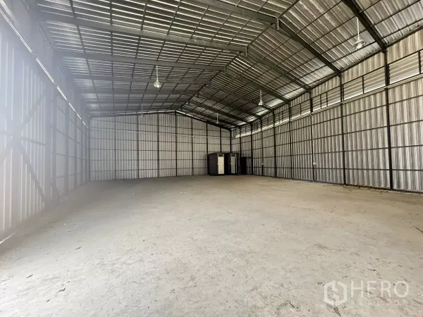 Warehouse for rent in Bang Lamung, Chon Buri - Open-plan warehouse space with high clear span and restrooms at the far end.