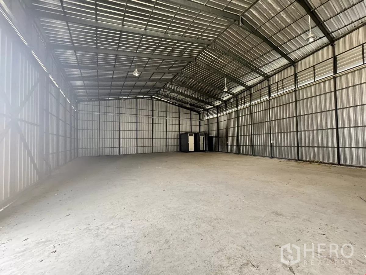 Warehouse for rent in Bang Lamung, Chon Buri - Open-plan warehouse space with high clear span and restrooms at the far end.