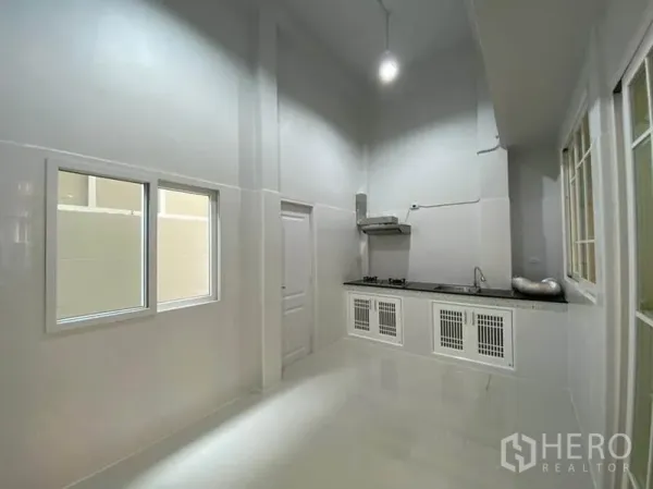ทาวน์เฮาส์ ให้เช่าในBang Na, Bangkok - ครัวไทยเพดานสูง เคาน์เตอร์ยาว เตาแก๊ส เครื่องดูดควัน และตู้สีขาว
