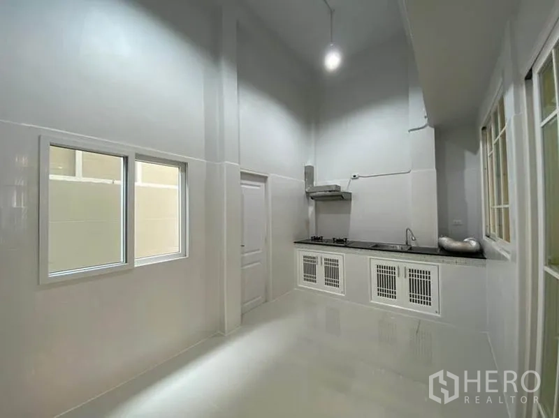 ทาวน์เฮาส์ ให้เช่าในBang Na, Bangkok - ครัวไทยเพดานสูง เคาน์เตอร์ยาว เตาแก๊ส เครื่องดูดควัน และตู้สีขาว