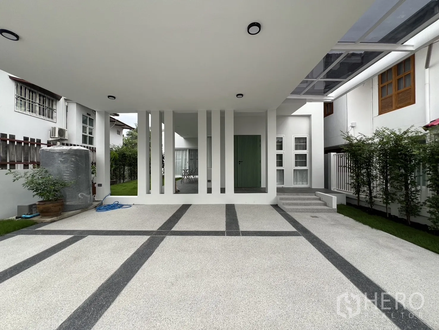 Detached House for rent in Saphan Sung, Bangkok - Patio and lush green lawn beside the house with potted plants.