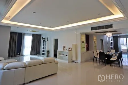 คอนโด ให้เช่าในWatthana, Bangkok - โซนนั่งเล่นและรับประทานอาหารสว่าง โปร่ง มีไฟฝ้าหลุม โซฟาสีขาว และประตูเชื่อมระเบียง