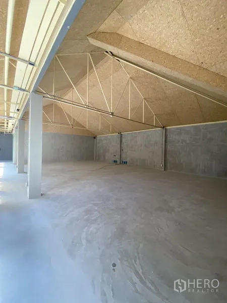 零售空间 出租在Watthana, Bangkok - 高挑坡顶与裸露桁架的开放式大空间，水泥地面适合多功能布局。