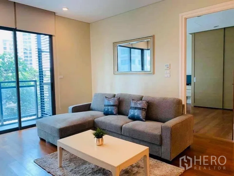 คอนโด ให้เช่าในKhlong Toei, Bangkok - ห้องนั่งเล่นโครงการ Bright Sukhumvit 24 โซฟาสีเทา โต๊ะกลาง และระเบียงวิวต้นไม้เมือง