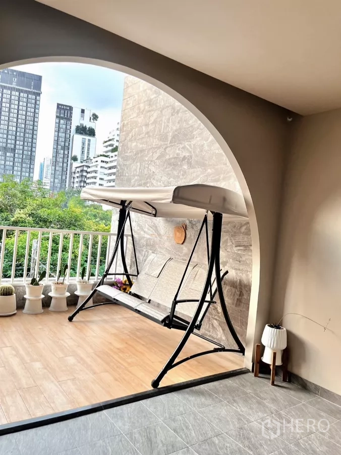 อาคารพาณิชย์ ให้เช่าในWatthana, Bangkok - ระเบียงโค้งระยะใกล้ มีชิงช้าและวิวตึกเมืองด้านหลัง