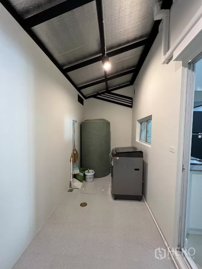 Townhouse for rent in Bang Kapi, Bangkok - Rear utility area with washing machine and water tank.